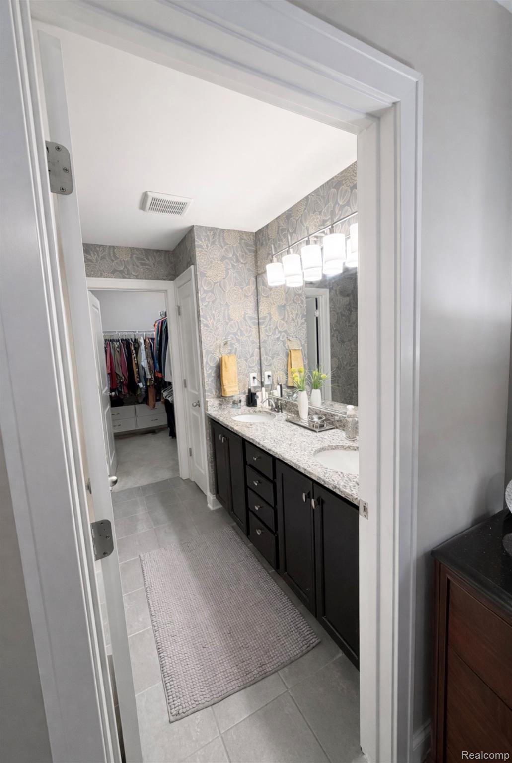 1876 Genoa Circle Howell, MI 48843 - Photo 15 of 36 Bathroom with double vanity, a spacious closet, and light tile patterned flooring