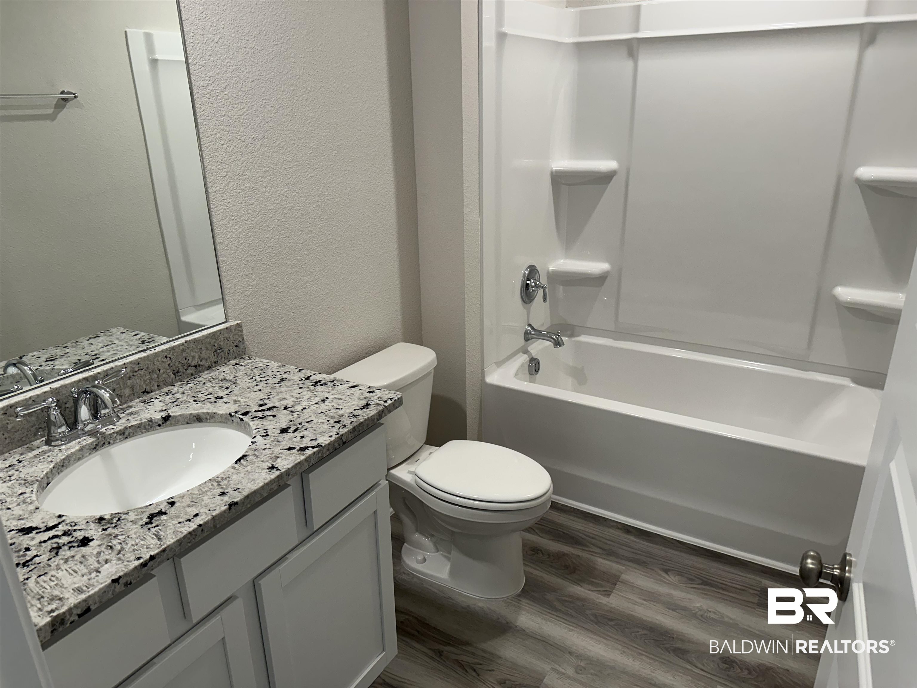 1238 Hayward Loop Foley, AL 36535 - Photo 13 of 46 Full bathroom featuring vanity, toilet, wood-type flooring, and bathtub / shower combination