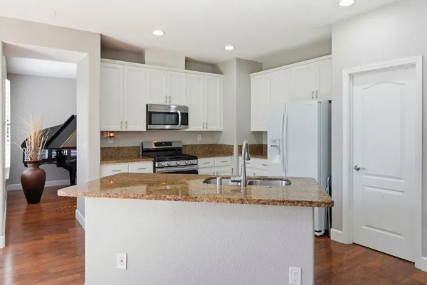 a kitchen with kitchen island a counter top space appliances and cabinets
