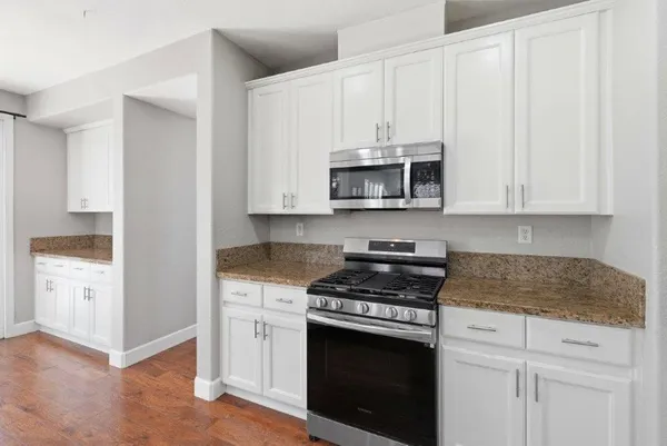 a kitchen with white cabinets and appliances