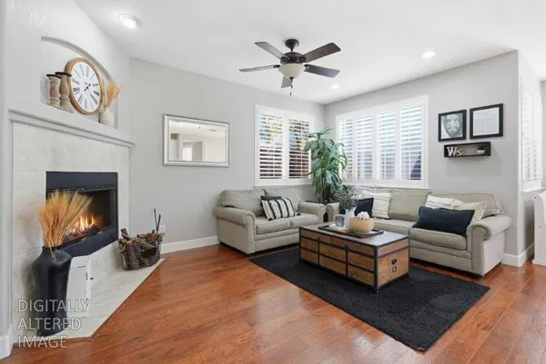 a living room with couches a flat tv screen and a fireplace