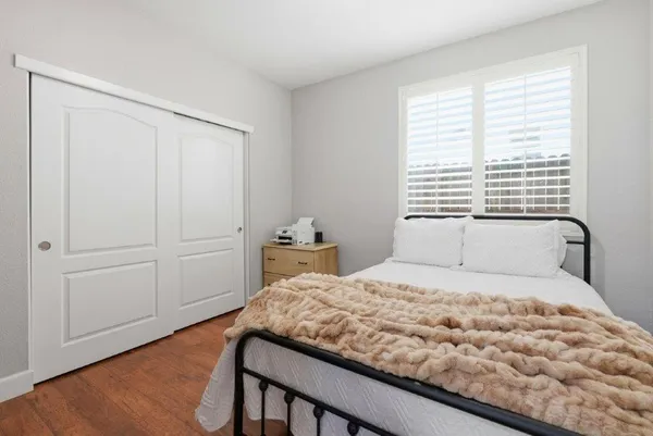 a bedroom with a bed and a window with wooden floor