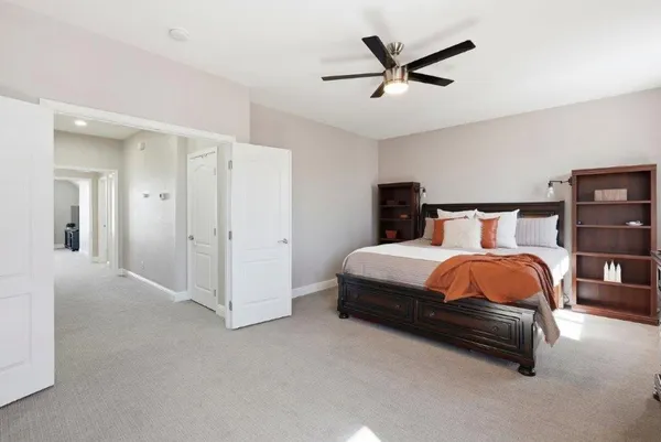 a bedroom with a bed and a ceiling fan