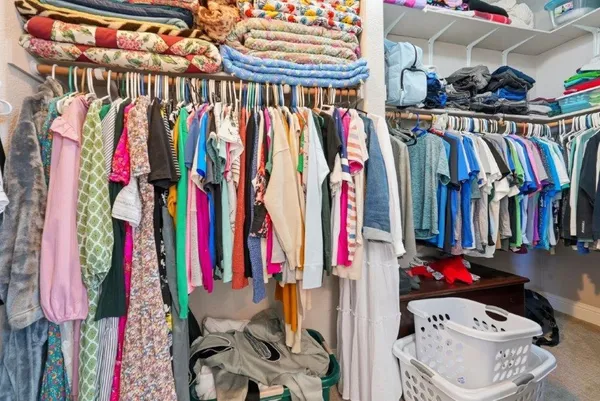 a view of walk in closet with clothes