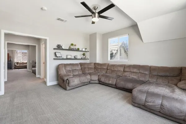 a living room with furniture and a ceiling fan