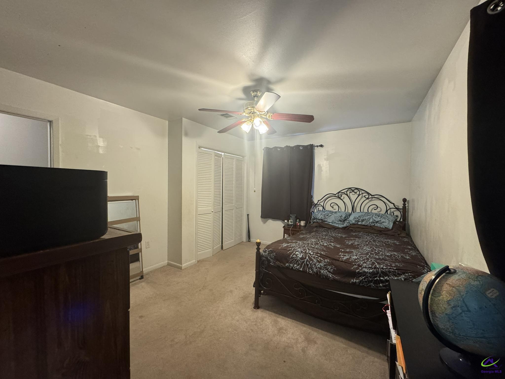1032 Elberta Road Warner Robins, GA 31093 - Photo 16 of 26 a bedroom with a bed and a flat tv screen on wall