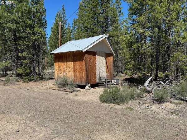 a view of a house with backyard and trees