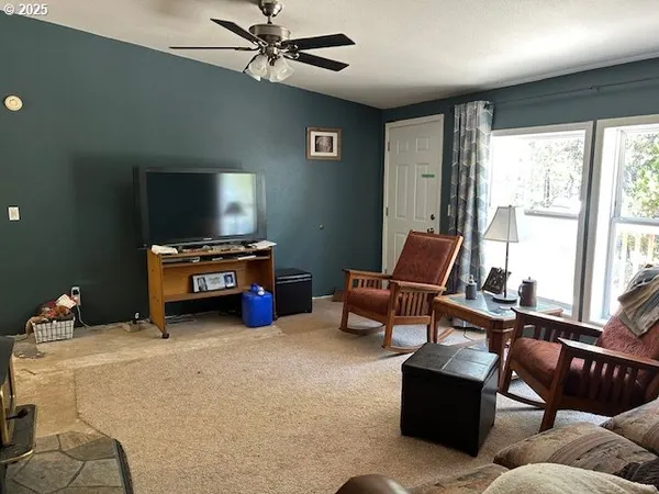a living room with furniture a ceiling fan and a window