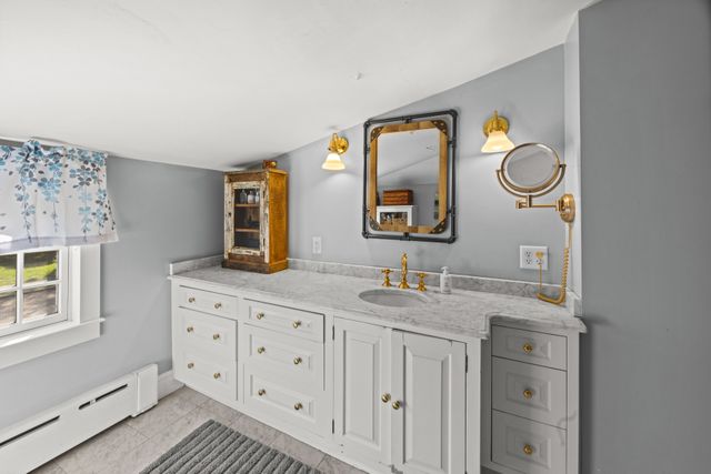a bathroom with a granite countertop double vanity sink and a mirror