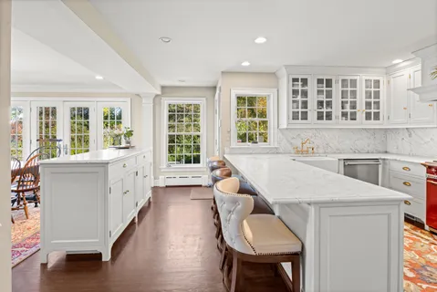 a living room with stainless steel appliances furniture and a large window