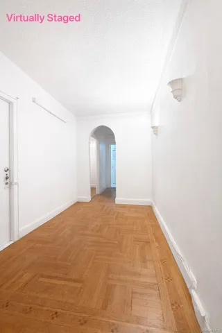 a view of a bedroom with wooden floor and window