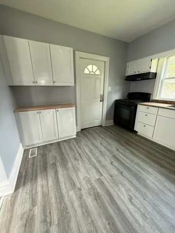 a kitchen with granite countertop a stove a sink and a refrigerator
