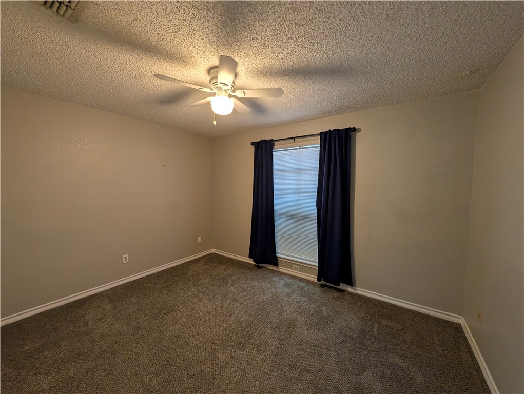4621 Constance Street Corpus Christi, TX 78413 - Photo 14 of 19 an empty room with a chandelier fan and windows