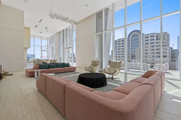 a living room with furniture a large window and a chandelier