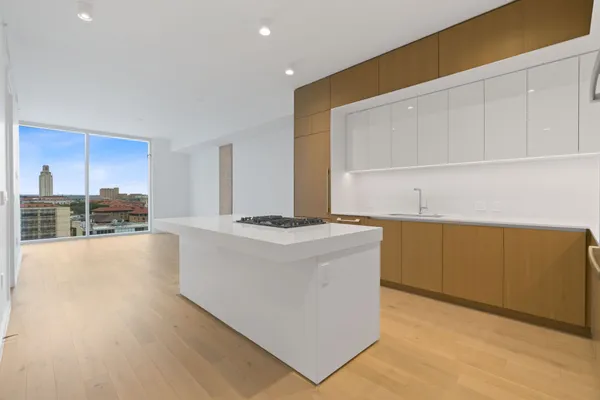 a living room with stainless steel appliances kitchen island granite countertop a stove a sink and a refrigerator