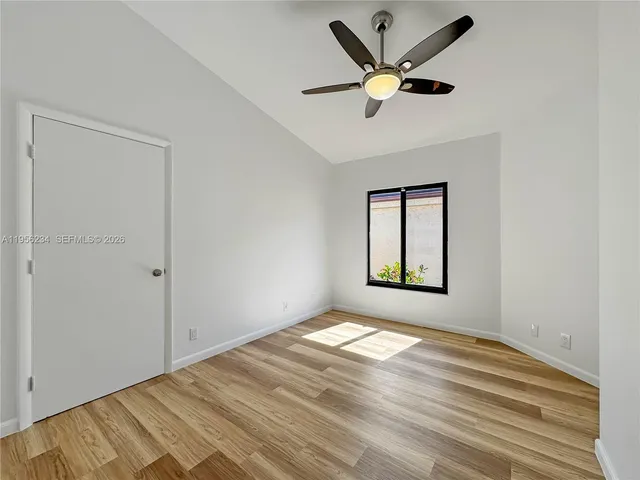 an empty room with window and ceiling fan