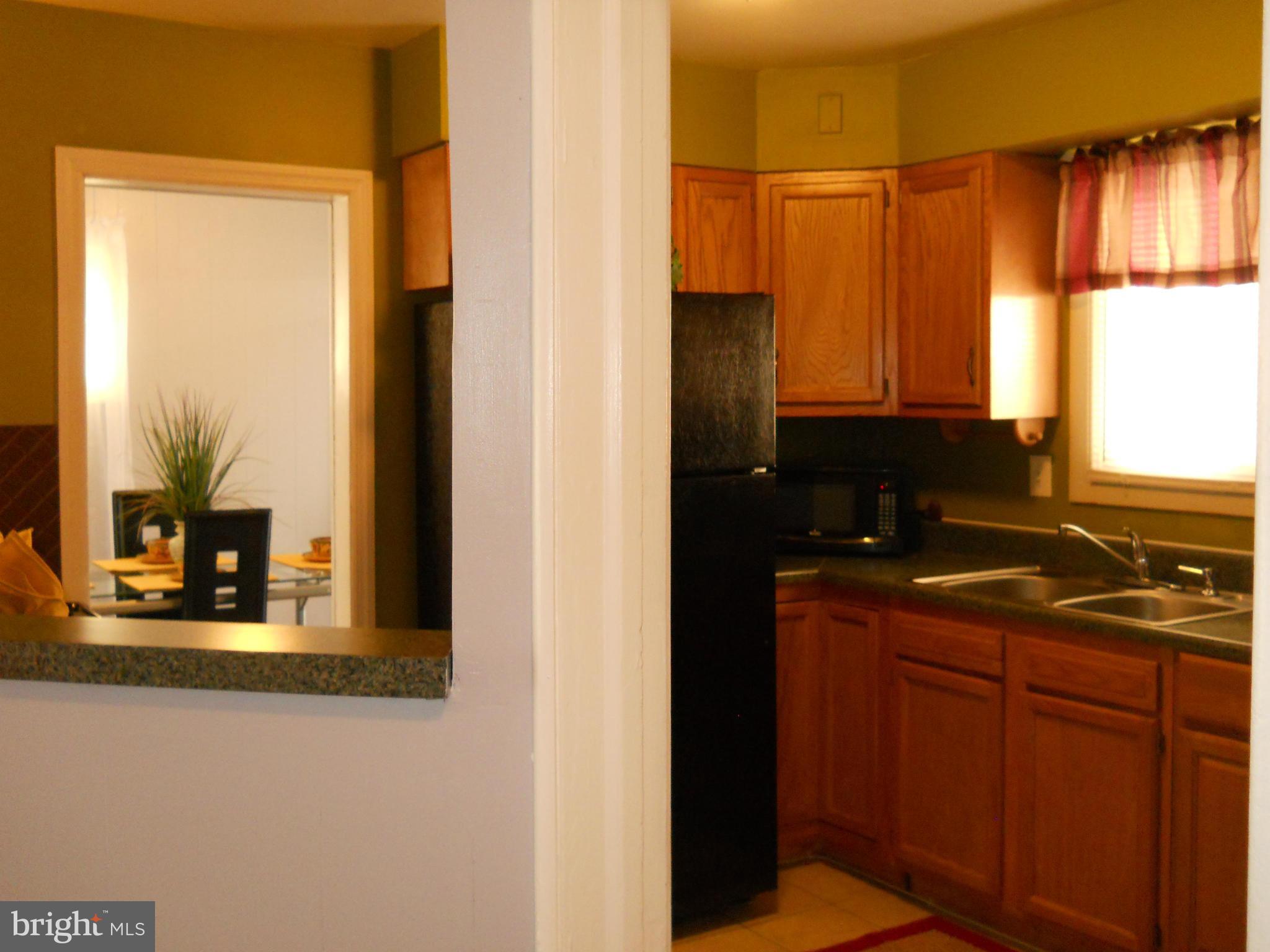 7411 Sudbrook Road Baltimore, MD 21208 - Photo 12 of 30 a kitchen with stainless steel appliances granite countertop a sink and a window