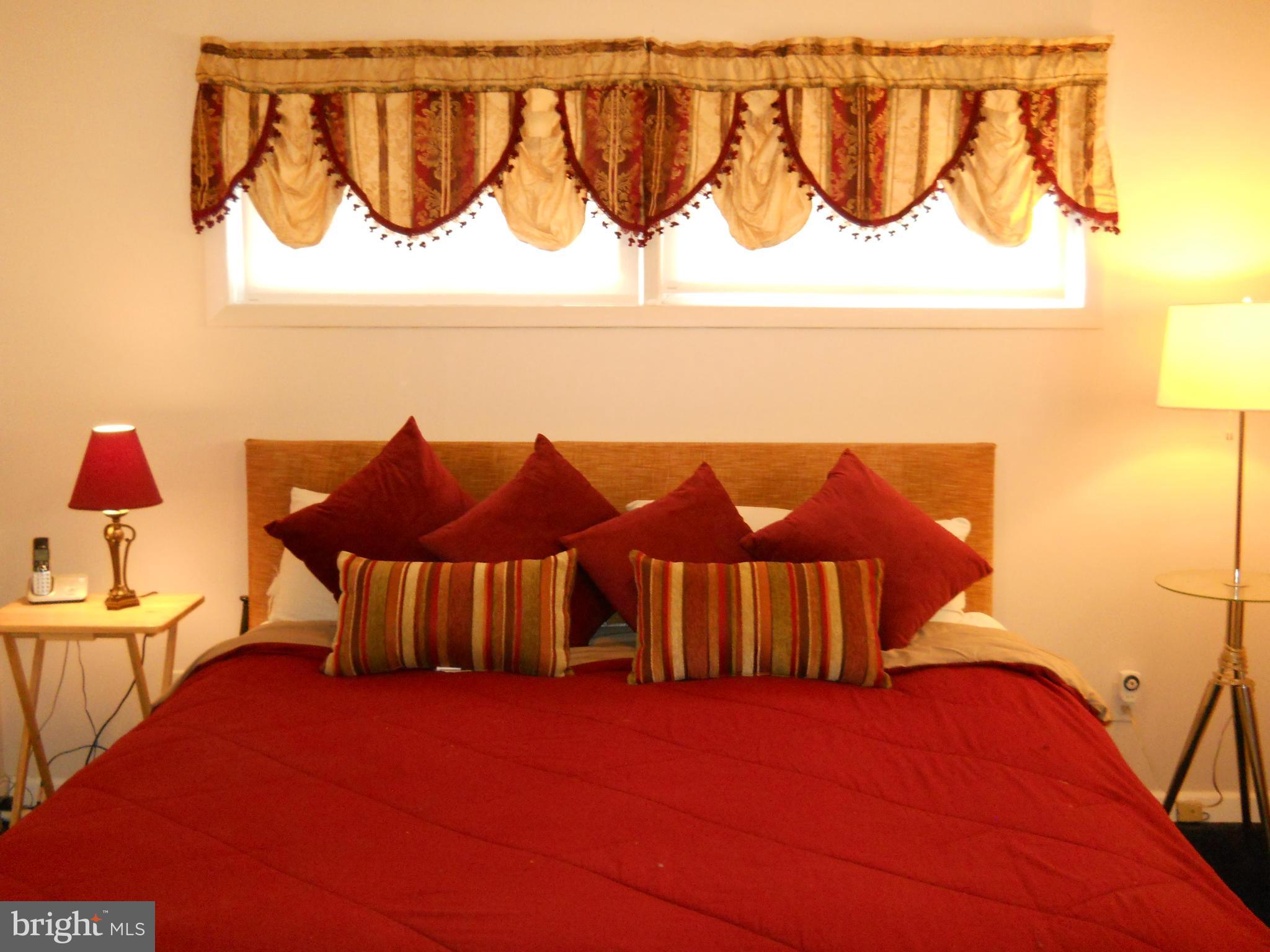 7411 Sudbrook Road Baltimore, MD 21208 - Photo 21 of 30 a view of a bedroom with a bed and a chandelier