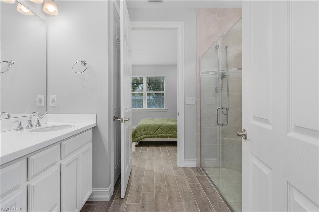 28367 Captiva Shell Loop Bonita Springs, FL 34135 - Photo 16 of 36 a en suite bathroom with a granite countertop sink a toilet a shower and a mirror