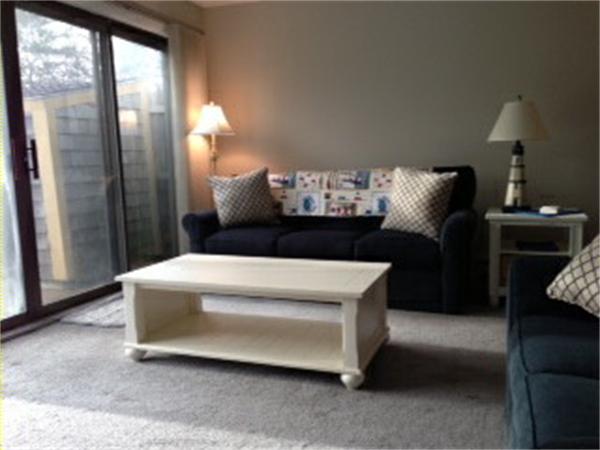 71 Round House Road, Unit 71 Bourne, MA 02532 - Photo 6 of 25 a living room with furniture and a chandelier