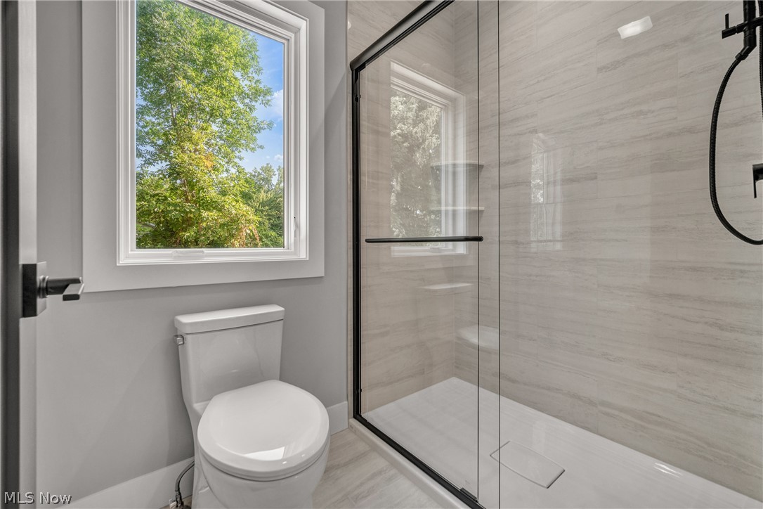 4009 Brainard Road Beachwood, OH 44122 - Photo 34 of 50 Bathroom featuring a shower with shower door, toilet, and plenty of natural light