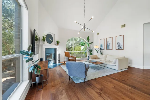a living room with fireplace furniture and a large window