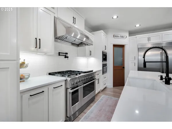 a kitchen with stainless steel appliances granite countertop a stove a sink and a refrigerator