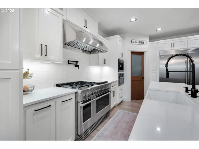 a kitchen with stainless steel appliances granite countertop a stove a sink and a refrigerator