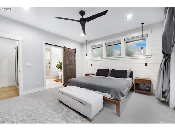 a bedroom with a bed a mirror and lamp