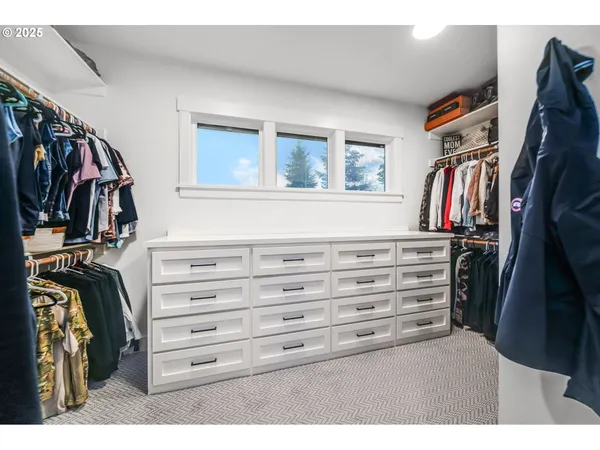 a view of walk in closet with clothes and shoes