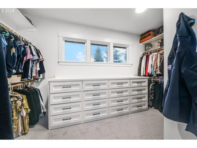 a view of walk in closet with clothes and shoes
