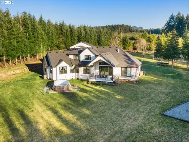 a aerial view of a house with swimming pool next to a big yard