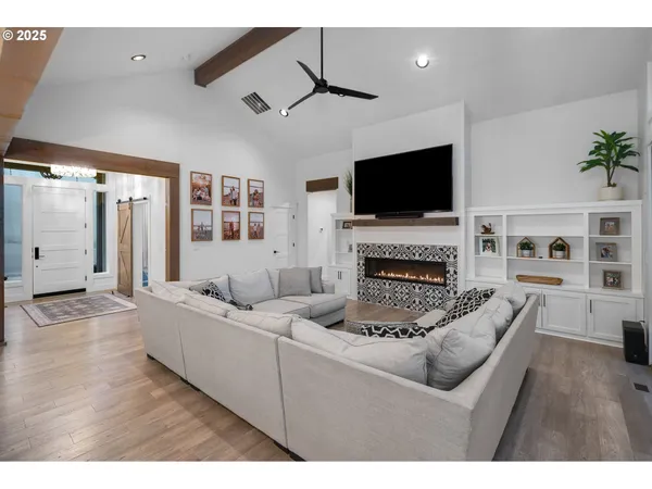 a living room with furniture a flat screen tv and a fireplace