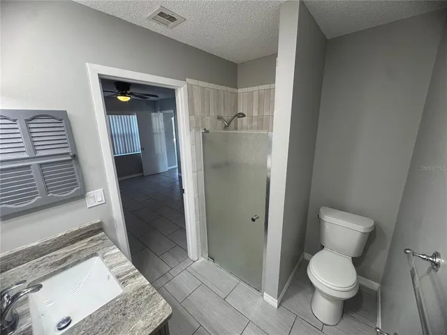 a bathroom with a granite countertop toilet and a sink