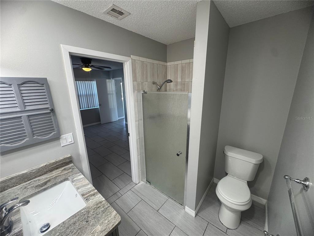 13016 Sirius Lane Hudson, FL 34667 - Photo 11 of 13 a bathroom with a granite countertop toilet and a sink