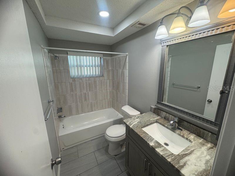 13016 Sirius Lane Hudson, FL 34667 - Photo 5 of 13 a bathroom with a granite countertop sink toilet a mirror and shower