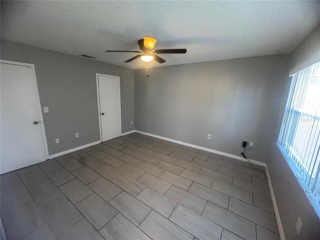 13016 Sirius Lane Hudson, FL 34667 - Photo 9 of 13 an empty room with windows and fan