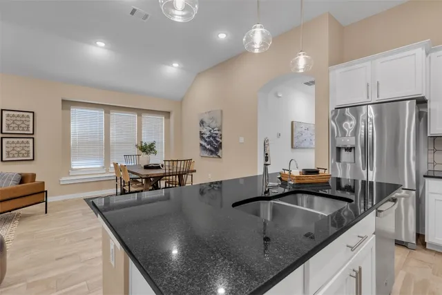 a kitchen with stainless steel appliances granite countertop a sink a stove and a refrigerator