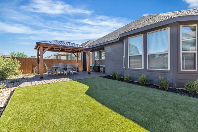a view of a house with backyard and sitting area