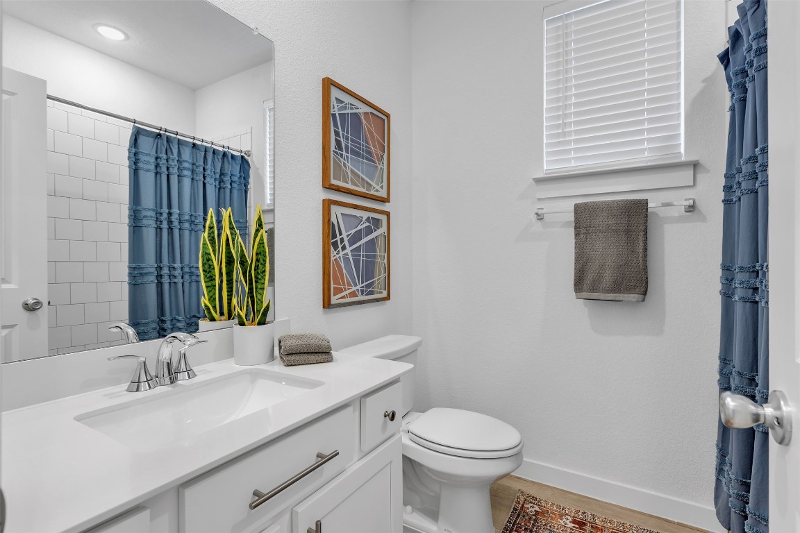 153 Billowing Way Kyle, TX 78640 - Photo 6 of 22 a bathroom with a granite countertop sink a toilet and mirror