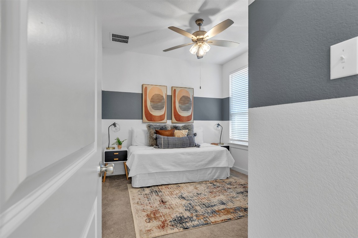 153 Billowing Way Kyle, TX 78640 - Photo 7 of 22 a bedroom with a bed and a chandelier