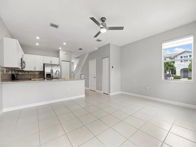 a view of kitchen view with stainless steel appliances refrigerator stove and a window