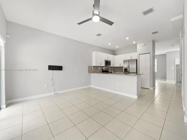 a view of kitchen with refrigerator and window