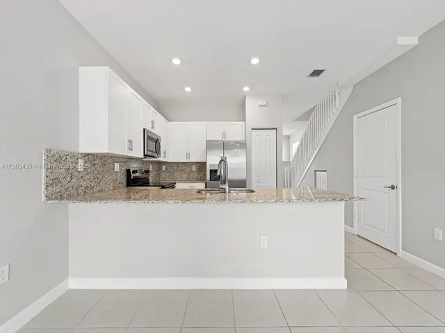 a view of a kitchen with kitchen island a counter top space and cabinets