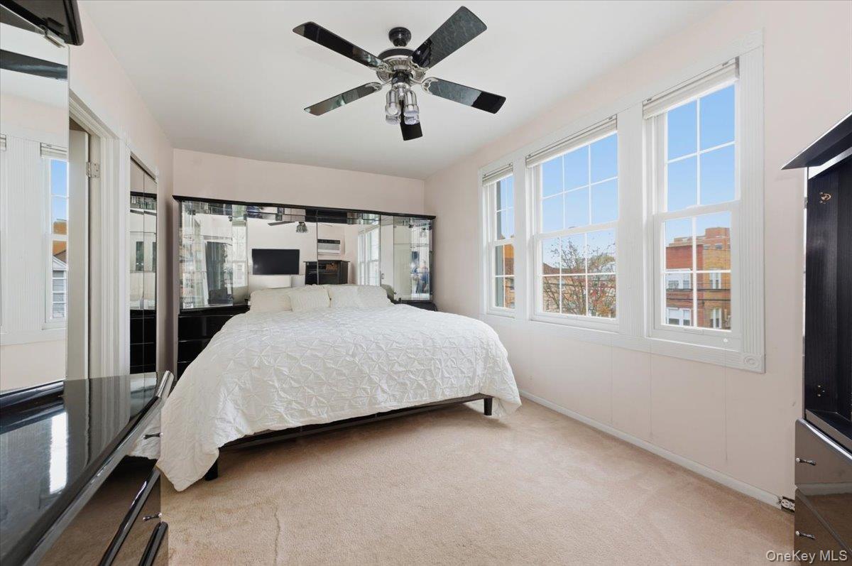 1617 Mahan Avenue Bronx, NY 10461 - Photo 12 of 29 a bedroom with a large bed and a chandelier