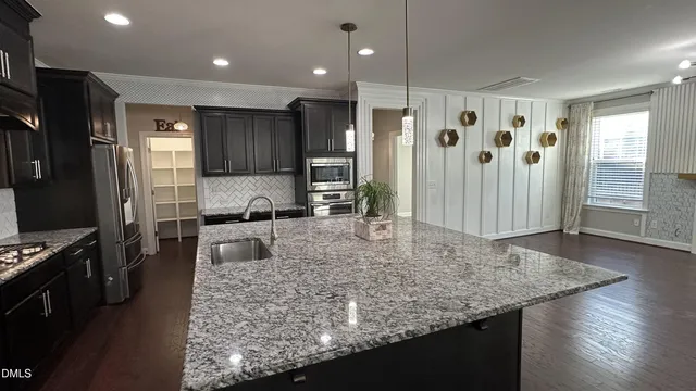 an empty room to hallway with wooden floor