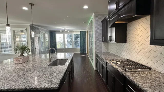 an empty room with wooden floor fireplace and windows