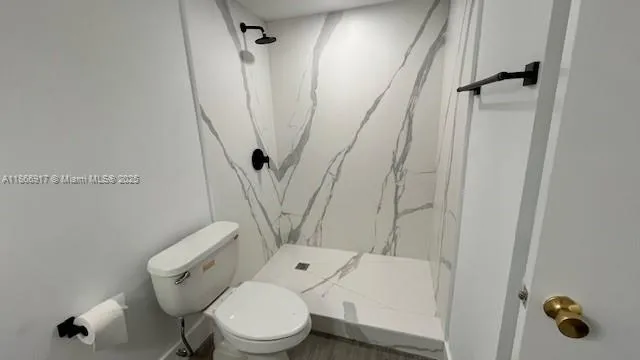a white toilet sitting next to a shower