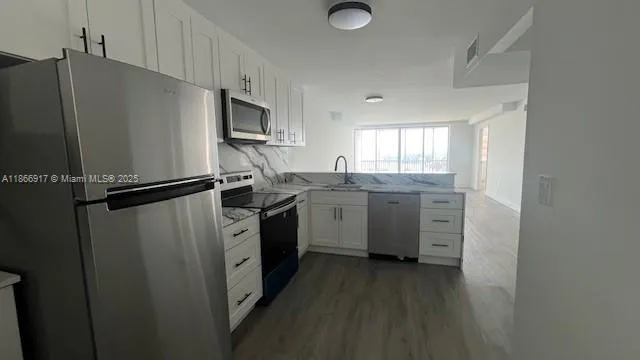 a kitchen with stainless steel appliances granite countertop a refrigerator sink and stove