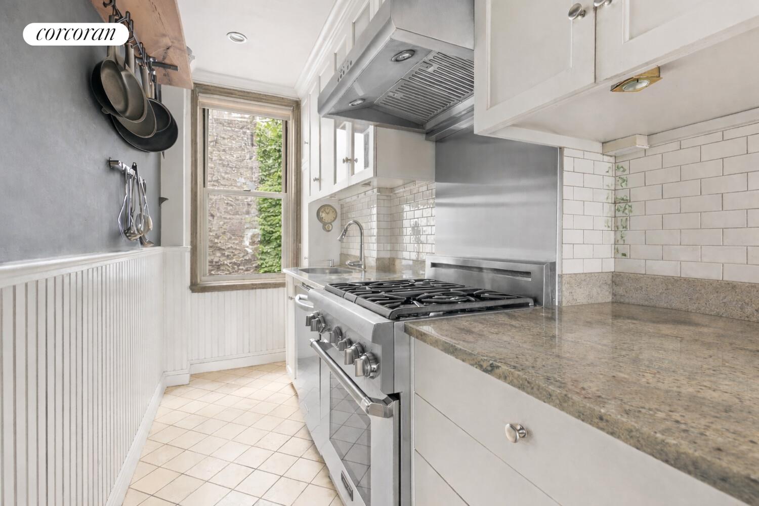 519 East 86th Street, Unit 6D Manhattan, NY 10028 - Photo 5 of 19 a kitchen with a stove and a wooden floor